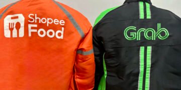 Dua pengemudi ojek online dari ShopeeFood dan Grab saat sedang menunggu pesanan. (Foto Oleh: Michelle Arletta, 21 Mei 2025)