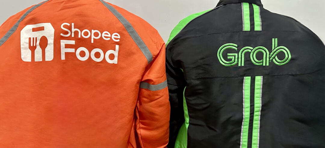 Dua pengemudi ojek online dari ShopeeFood dan Grab saat sedang menunggu pesanan. (Foto Oleh: Michelle Arletta, 21 Mei 2025)