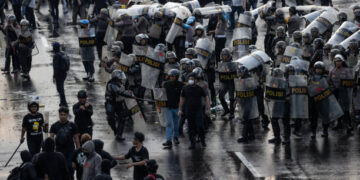 SURABAYA, INDONESIA - MARCH 24: Activists clash with Indonesian Police officers during a protest against the military law revision on March 24, 2025 in Surabaya, Indonesia. On March 20, Indonesia's House of Representatives passed a revision to military law, allowing military officers to serve in more government posts and take up civilian positions without resigning from the Indonesian National Armed Forces. This amendment has drawn criticism from civil society groups, who warn it could signal a return to the repressive New Order era under former President Soeharto, when military officers dominated civilian affairs.Critics argue that this change could lead to abuse of power, human rights violations, and political impunity for army personnel, reminiscent of the era under dictator Suharto, who stepped down in 1998. The timing is particularly significant as Indonesia is now led by President Prabowo Subianto, an ex-special forces general and former son-in-law of Suharto, who was inaugurated in October 2024. (Photo by Robertus Pudyanto/Getty Images)