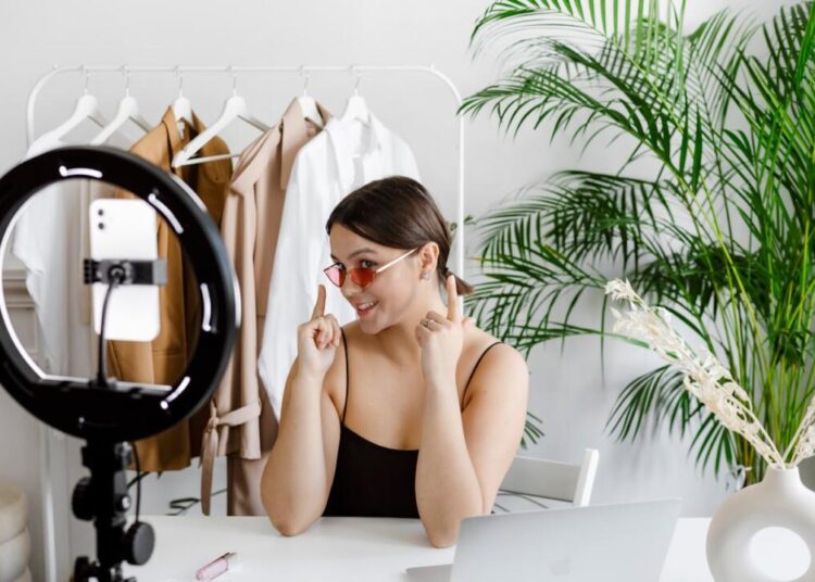 Ilustrasi seorang perempuan sedang berjualan menggunakan fitur Live Shopping.