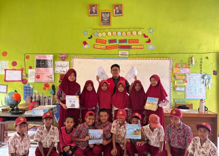 Mahasiswa KKN-T 114 Unhas dan siswa menunjukkan hasil ulasan buku yang mereka buat.