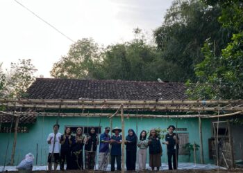 dokumentasi Mahasiswa KKN bersama warga sedang menanam bibit cabai atau terong di lahan.