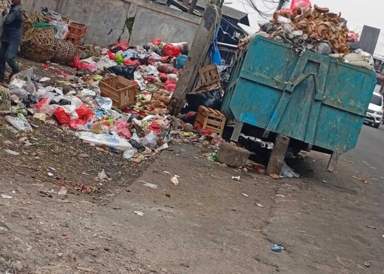 Ciputat, Tangerang Selatan – Penumpukan sampah kembali terjadi di kawasan Pasar Cimanggis, Ciputat, Tangerang Selatan. Berdasarkan pantauan di lokasi pada Minggu (5/10/2025), tumpukan sampah terlihat berserakan di sekitar area pasar dan di pinggir jalan, bahkan sebagian sudah menumpuk hingga meluber dari bak penampungan. Sampah yang didominasi oleh sisa sayur, plastik, dan bahan organik lain ini menimbulkan bau tidak sedap serta menjadi pemandangan yang kurang enak bagi warga dan pengunjung pasar. Beberapa pedagang dan warga sekitar mengaku terganggu dengan kondisi tersebut karena menimbulkan aroma busuk dan mengundang lalat. Kondisi ini juga dikhawatirkan dapat mencemari lingkungan dan menimbulkan risiko kesehatan masyarakat sekitar. Sampah yang berserakan di jalan membuat akses keluar masuk pasar menjadi tidak nyaman bagi pengunjung maupun kendaraan. Saya berharap Dinas Lingkungan Hidup Kota Tangerang Selatan segera melakukan penanganan lebih rutin dan menambah armada pengangkutan sampah di area pasar agar tidak menumpuk seperti sekarang.