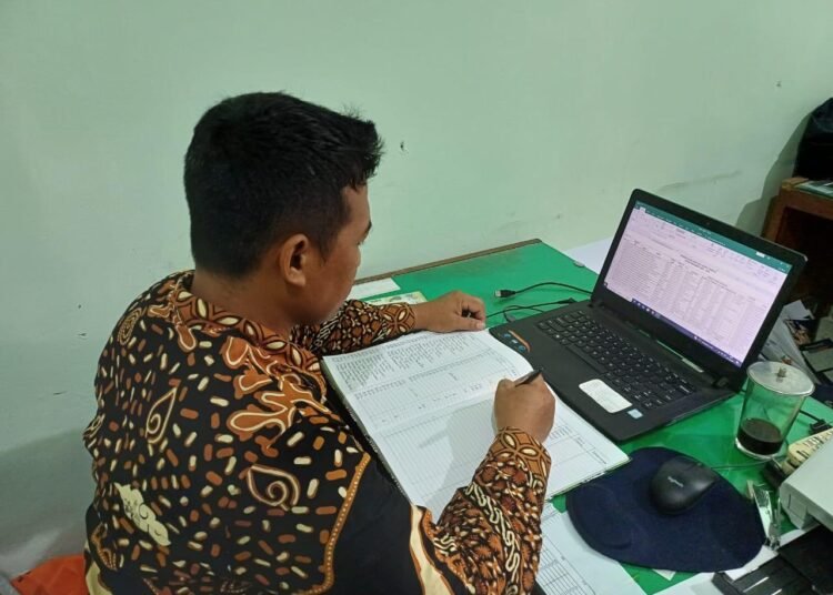 Pegawai Tata Usaha MTsN 6 Bantul Rapikan Data SIswa dalam Buku Kleper 46 MTsN 6 Bantul