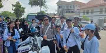 Petugas berinteraksi dengan wisatawan di sekitaran Kebun Raya Bogor