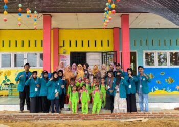 Aceh Utara — Suasana penuh warna dan keceriaan tampak jelas di lingkungan TK Negeri Pembinaan Kecamatan Kuta Makmur, Aceh Utara, saat Kelompok 41 mahasiswa UIN Sultanah Nahrasiyah melaksanakan kunjungan edukatif pada kegiatan pengabdian dan interaksi sosial, Minggu (tanggal kegiatan dapat disesuaikan). Kunjungan ini disambut hangat oleh para guru, tenaga pendidik, serta anak–anak TK yang tampil ceria dengan seragam hijau mencolok yang memberikan nuansa semangat dan energi positif. Para mahasiswa tampil kompak dengan seragam jaket biru muda, mencerminkan karakter disiplin sekaligus siap berkarya. Dalam kegiatan ini, para mahasiswa terlibat aktif dalam berbagai bentuk interaksi, mulai dari pendampingan belajar, permainan edukatif, hingga pembiasaan karakter. Meskipun anak–anak masih berada di usia dini, semangat belajar dan rasa ingin tahu yang tinggi tampak jelas, menciptakan suasana yang hangat dan penuh tawa. Para guru dan pendidik di lokasi menyampaikan apresiasi atas kunjungan tersebut. Menurut mereka, kehadiran mahasiswa tidak hanya memberikan warna baru bagi anak-anak, tetapi juga memberi inspirasi tentang pentingnya pendidikan sejak dini dan hubungan positif antara dunia kampus serta lembaga pendidikan dasar. Mahasiswa Kelompok 41 juga menegaskan bahwa kunjungan ini merupakan bentuk komitmen dalam menjalankan Tri Dharma Perguruan Tinggi, khususnya pengabdian masyarakat. Selain itu, kegiatan ini diharapkan mampu memperkuat hubungan antara institusi pendidikan tinggi dengan sekolah-sekolah di daerah, terutama dalam mengembangkan kreativitas, karakter, dan keceriaan anak-anak. Bangunan sekolah yang dihiasi mural ikan-ikan laut, bunga warna-warni, dan hiasan gantung berwarna cerah turut menambah kehangatan suasana. Para mahasiswa, guru, serta anak-anak berfoto bersama sebagai simbol kebersamaan dan kenangan berharga di hari itu. Sebagai bentuk tindak lanjut, mahasiswa berencana untuk mengadakan kegiatan lanjutan berupa pelatihan kreatif dan permainan edukasi yang dapat membantu pengembangan motorik serta kecerdasan sosial-emosional anak. Tujuan ini sejalan dengan upaya membangun pondasi pembelajaran yang lebih menyenangkan dan berkualitas untuk anak usia dini di wilayah Kuta Makmur. Kegiatan ini juga menjadi momen refleksi bagi mahasiswa, di mana mereka dapat melihat langsung bagaimana pentingnya peran guru dalam membentuk karakter anak sejak usia dini. Pengalaman berinteraksi langsung dengan anak-anak memberikan motivasi baru bagi mahasiswa untuk terus mengembangkan kemampuan pedagogik, empati, dan komunikasi interpersonal yang menjadi bekal penting bagi mereka di masa depan.