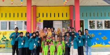 Aceh Utara — Suasana penuh warna dan keceriaan tampak jelas di lingkungan TK Negeri Pembinaan Kecamatan Kuta Makmur, Aceh Utara, saat Kelompok 41 mahasiswa UIN Sultanah Nahrasiyah melaksanakan kunjungan edukatif pada kegiatan pengabdian dan interaksi sosial, Minggu (tanggal kegiatan dapat disesuaikan). Kunjungan ini disambut hangat oleh para guru, tenaga pendidik, serta anak–anak TK yang tampil ceria dengan seragam hijau mencolok yang memberikan nuansa semangat dan energi positif. Para mahasiswa tampil kompak dengan seragam jaket biru muda, mencerminkan karakter disiplin sekaligus siap berkarya. Dalam kegiatan ini, para mahasiswa terlibat aktif dalam berbagai bentuk interaksi, mulai dari pendampingan belajar, permainan edukatif, hingga pembiasaan karakter. Meskipun anak–anak masih berada di usia dini, semangat belajar dan rasa ingin tahu yang tinggi tampak jelas, menciptakan suasana yang hangat dan penuh tawa. Para guru dan pendidik di lokasi menyampaikan apresiasi atas kunjungan tersebut. Menurut mereka, kehadiran mahasiswa tidak hanya memberikan warna baru bagi anak-anak, tetapi juga memberi inspirasi tentang pentingnya pendidikan sejak dini dan hubungan positif antara dunia kampus serta lembaga pendidikan dasar. Mahasiswa Kelompok 41 juga menegaskan bahwa kunjungan ini merupakan bentuk komitmen dalam menjalankan Tri Dharma Perguruan Tinggi, khususnya pengabdian masyarakat. Selain itu, kegiatan ini diharapkan mampu memperkuat hubungan antara institusi pendidikan tinggi dengan sekolah-sekolah di daerah, terutama dalam mengembangkan kreativitas, karakter, dan keceriaan anak-anak. Bangunan sekolah yang dihiasi mural ikan-ikan laut, bunga warna-warni, dan hiasan gantung berwarna cerah turut menambah kehangatan suasana. Para mahasiswa, guru, serta anak-anak berfoto bersama sebagai simbol kebersamaan dan kenangan berharga di hari itu. Sebagai bentuk tindak lanjut, mahasiswa berencana untuk mengadakan kegiatan lanjutan berupa pelatihan kreatif dan permainan edukasi yang dapat membantu pengembangan motorik serta kecerdasan sosial-emosional anak. Tujuan ini sejalan dengan upaya membangun pondasi pembelajaran yang lebih menyenangkan dan berkualitas untuk anak usia dini di wilayah Kuta Makmur. Kegiatan ini juga menjadi momen refleksi bagi mahasiswa, di mana mereka dapat melihat langsung bagaimana pentingnya peran guru dalam membentuk karakter anak sejak usia dini. Pengalaman berinteraksi langsung dengan anak-anak memberikan motivasi baru bagi mahasiswa untuk terus mengembangkan kemampuan pedagogik, empati, dan komunikasi interpersonal yang menjadi bekal penting bagi mereka di masa depan.