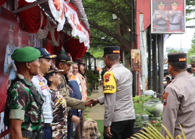 Waka Polda Jateng Kunjungi Pos Pelayanan Operasi Lilin di Alun-Alun Rembang 46 Waka Polda Jateng Kunjungi Pos Pelayanan Operasi Lilin di Alun-Alun Rembang Rembang – Wakil Kepala Kepolisian Daerah Jawa Tengah (Waka Polda Jateng) melaksanakan kunjungan kerja ke Pos Pelayanan Operasi Lilin yang berlokasi di Alun-Alun Rembang. Kunjungan ini dilakukan untuk memastikan kesiapan personel serta sarana prasarana dalam rangka pengamanan Natal dan Tahun Baru. Dalam kegiatan tersebut, Waka Polda Jateng didampingi pejabat utama Polda Jawa Tengah, unsur TNI, serta instansi terkait. Ia meninjau langsung kondisi pos pelayanan, kelengkapan peralatan pendukung, serta kesiapsiagaan personel gabungan yang bertugas memberikan pelayanan kepada masyarakat. Waka Polda Jateng juga memberikan arahan dan motivasi kepada para petugas agar senantiasa menjaga kesehatan, meningkatkan kewaspadaan, serta memberikan pelayanan yang humanis dan profesional kepada masyarakat. Selain itu, ia menyerahkan bantuan logistik sebagai bentuk dukungan moril bagi personel di lapangan. “Kehadiran Pos Pelayanan Operasi Lilin ini diharapkan dapat memberikan rasa aman dan nyaman kepada masyarakat, khususnya selama perayaan Natal dan Tahun Baru,” ungkapnya. Melalui kegiatan ini, Polda Jawa Tengah berkomitmen untuk memastikan seluruh rangkaian Operasi Lilin berjalan aman, lancar, dan kondusif, serta memperkuat sinergitas antara Polri, TNI, dan pemerintah daerah dalam menjaga keamanan dan ketertiban masyarakat di wilayah Kabupaten Rembang.