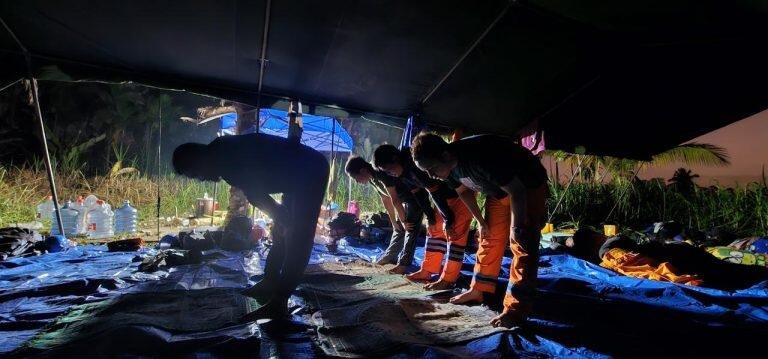 500 Personel PLN Tiba di Lokasi Banjir, Percepat Pemulihan Sistem Kelistrikan di Aceh 48 Tampak petugas PLN sedang beribadah di sela pemulihan jaringan kelistrikan yang berlangsung 24 jam. Para petugas bermalam di tenda darurat yang didirikan di area tower terdampak Kabupaten Bireuen, Aceh.