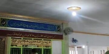 Pulau Cangkir mungkin tampak seperti sebuah pulau kecil yang tenang di pesisir utara Banten. Namun, di balik kesederhanaannya, wilayah ini menyimpan jejak panjang perjalanan Sejarah, terutama dalam konteks penyebaran Islam di Banten pada abad ke-16. Banyak orang mengenal Pulau Cangkir sebagai lokasi makam Syekh waliyuddin atau pangeran jaga lautan, salah satu tokoh penyebar Islam di kawasan tersebut. Tetapi tak banyak yang mengetahui bahwa pulau kecil ini pernah memainkan peran penting dalam jaringan dakwah dan perdagangan pada masa kesultanan Banten. Pada abad ke-16, Banten muncul sebagai salah satu pusat kekuasaan besar di Nusantara. Kesultanan Banten saat itu tidak hanya terkenal sebagai Pelabuhan dagang internasional, tetapi juga sebagai pusat perkembangan agama Islam. Para ulama, pedagang, dan bangsawan bekerja saama dalam menyebarkan ajaran Islam ke pedalaman maupun pesisir. Di sinilah Pulau Cangkir mendapat tempat dalam Sejarah. Letaknya yang strategis di jalur masuk menuju Banten lama menjadikannya ruang singgah yang penting bagi para pedagang serta pendakwah. Sosok yang tak bisa dipisahkan dari cerita Pulau Cangkir adalah Syekh Waliyuddin, kehadirannya di Pulau Cangkir bukan hanya sekedar menyendiri atau bermeditasi, tetapi membangun pusat dakwah yang menjadi tempat belajar bagi masyarakat sekitar. Selain dakwah, Pulau Cangkir juga menjadi titik pertemuan budaya. Hubungan antara pedagang dan penduduk lokal menciptakan ruang dialog yang alami, sehingga ajaran Islam diterima dengan cara yang damai dan perlahan. Kehidupan sehari-hari Masyarakat pesisir yang terbuka dan penuh interaksi menjadi jalan masuk yang efektif bagi para ulama dalam mengenalkan ajaran agama. Seiring berjalannya waktu, aktivitas perdagangan di Pulau Cangkir memang tak lagi sepadat dulu. Namun, nilai historis dan spiritualnya justru semakin kuat. Tradisi ziarah ke makam Syekh Waliyuddin tetap hidup, bahkan menjadi bagian penting dari identiatas Masyarakat Banten. Banyak orang datang bukan hanya untuk berdoa, tetapi juga untuk merasakan suasana tenang dan historis yang sulit ditemukan di tempat lain. Kini, Pulau Cangkir dikenal sebagai salah satu destinasi religi yang cukup ramai dikunjungi. Pemerintah setempat pun terus memperbaiki fasilitas tanpa menghilangkan nuansa sejarahnya. Saat menginjakkan kaki disana, kita seakan diajak kembali ke masa lalu membayangkan bagaimana para ulama, pedagang, dan masyarakat saling bertemu, berdialog, dan membangun kehidupan Islam di Banten. Pada akhirnya pulau Cangkir bukan hanya cerita tentang masa kini dengan masa lalu, tetapi sebuah pengingat tentang semangat dakwah, perdagangan, dan kebudayaan yang membentuk wajah Banten hingga hari ini. Dengan memahami sejarahnya, kita dapat melihat bagaimana sebuah Pulau kecil memberi kontribusi signifikan terhadap perkembangan Islam di Nusantara.