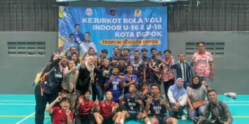 "Potret kebersamaan tim bola voli IRENA beserta jajaran pelatih, ofisial, dan pendukung usai pertandingan. Berpose di bawah spanduk Kejurkot Kota Depok, foto ini menyimbolkan kekompakan dan solidaritas keluarga besar tim yang menjadi fondasi utama kesuksesan mereka dalam turnamen ini."