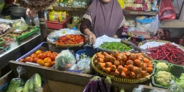 Pedagang sayur di Pasar Ciplak, Jakarta Timur, Sabtu (10/1/2026), di tengah kenaikan harga bahan pangan.