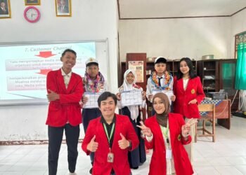 Mahasiswa KKN R9 Universitas 17 Agustus 1945 Surabaya berfoto bersama di ruang TIK SMP Negeri 3 Pacet setelah pelaksanaan kegiatan edukasi kewirausahaan.