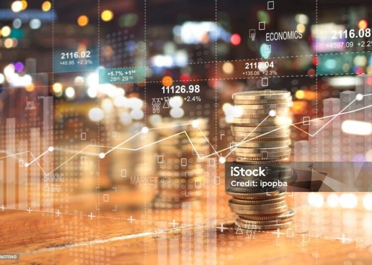 Double explosure with businesss charts of graph and rows of coins for finance at night city background.
