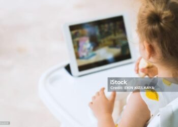 CUte toddler girl watching tablet on mealtime