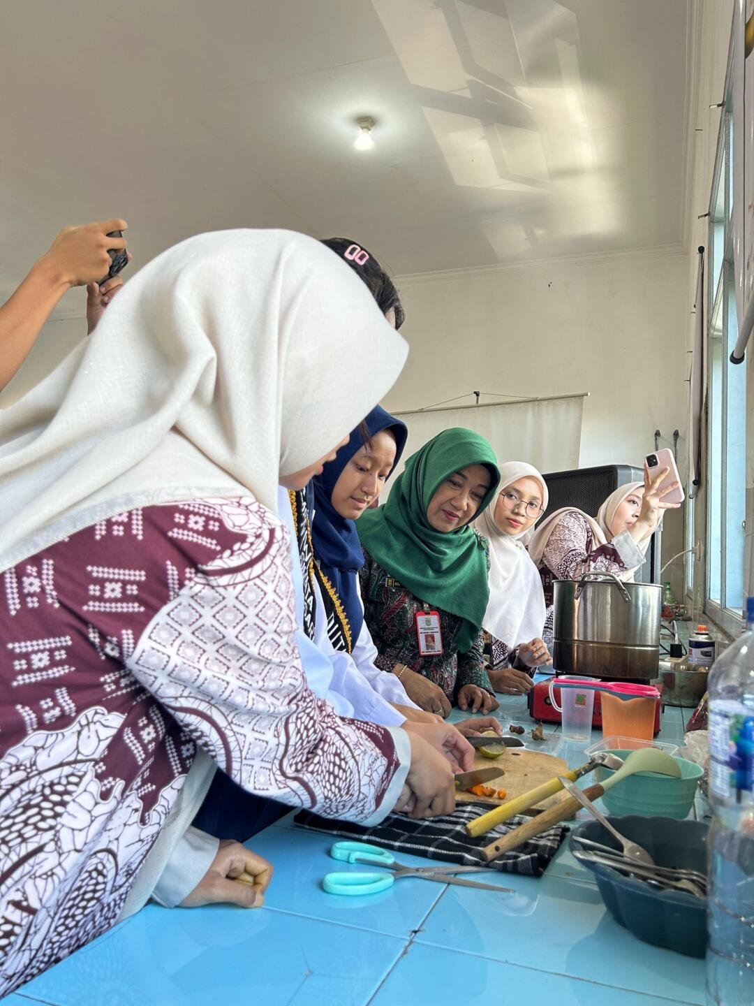 Praktik pembuatan jamu kunyit bunga sepatu oleh duta dan kader Adiwiyata dan PJAS SMPN 1 Singosari dengan pendampingan tim KKM 50 UIN Malang dalam kegiatan sosialisasi, Kamis (23/4/2026).