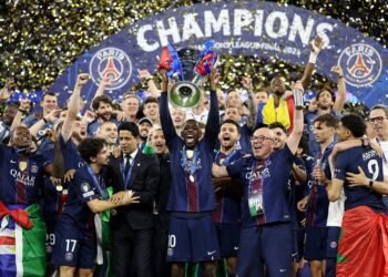 Skuad PSG beserta staff melakukan selebrasi mengangkat trofi UCL di atas podium (Sumber: Instagram/Ousmane Dembele)