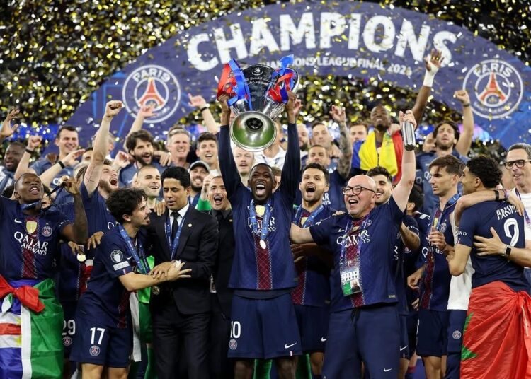 Mimpi Buruk di Budapest: Arsenal Gagal Ukir Sejarah, Dominasi Inggris di Eropa Terhenti 46 Skuad PSG beserta staff melakukan selebrasi mengangkat trofi UCL di atas podium (Sumber: Instagram/Ousmane Dembele)