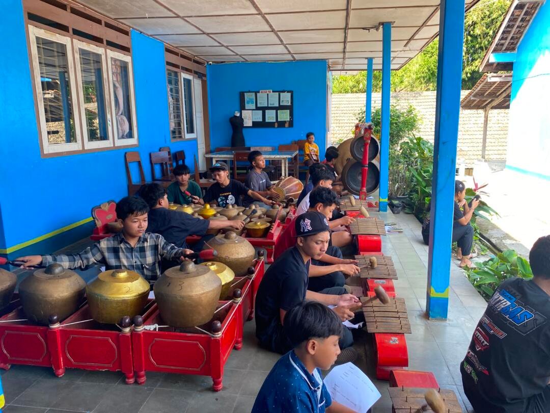 Potret murid-murid memainkan gamelan.
