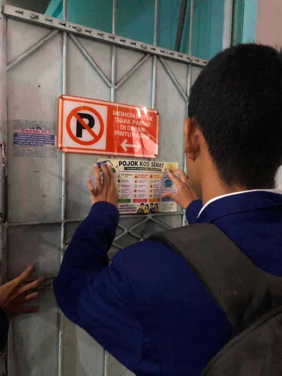Pojok Kos Sehat: Upaya Edukasi Hidup Bersih dan Sehat Melalui Media Poster di Lingkungan Kos 48 Mahasiswa PGSD Universitas Negeri Yogyakarta saat sedang memasang poster "Pojok Kost Sehat"