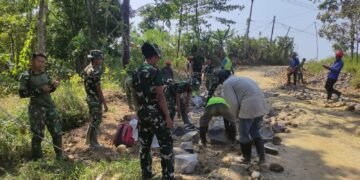 Personel Satgas TMMD Ke-129 Kodim 0601/Pandeglang bersama warga bergotong royong menyusun batu untuk pengerasan badan jalan penghubung Kampung Pangburangan, Desa Pasirgadung dengan Kampung Ciririgi, Desa Simpangtiga, Kecamatan Patia, Kabupaten Pandeglang.