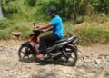 Pengendara sepeda motor melintasi jalan hasil pembangunan TMMD Ke-129 Kodim 0601/Pandeglang di Desa Pasirgadung, Kecamatan Patia, yang kini mempermudah aktivitas dan mobilitas warga.