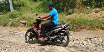 Pengendara sepeda motor melintasi jalan hasil pembangunan TMMD Ke-129 Kodim 0601/Pandeglang di Desa Pasirgadung, Kecamatan Patia, yang kini mempermudah aktivitas dan mobilitas warga.