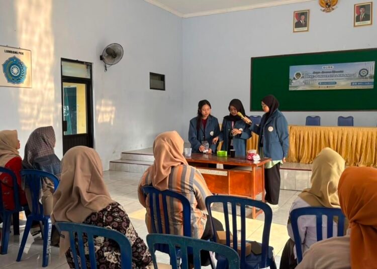 Inovasi Sabun Ekstrak Pandan dan Jeruk Nipis: Mahasiswa KKN-BBK 8 UNAIR Berdayakan Perempuan Desa Pilangrejo Wujudkan SDGs 4 46 Tiga mahasiswa BBK 8 UNAIR sedang berdiri di depan mendemonstrasikan pembuatan sabun cuci piring kepada ibu-ibu PKK Desa Pilangrejo yang duduk memperhatikan.