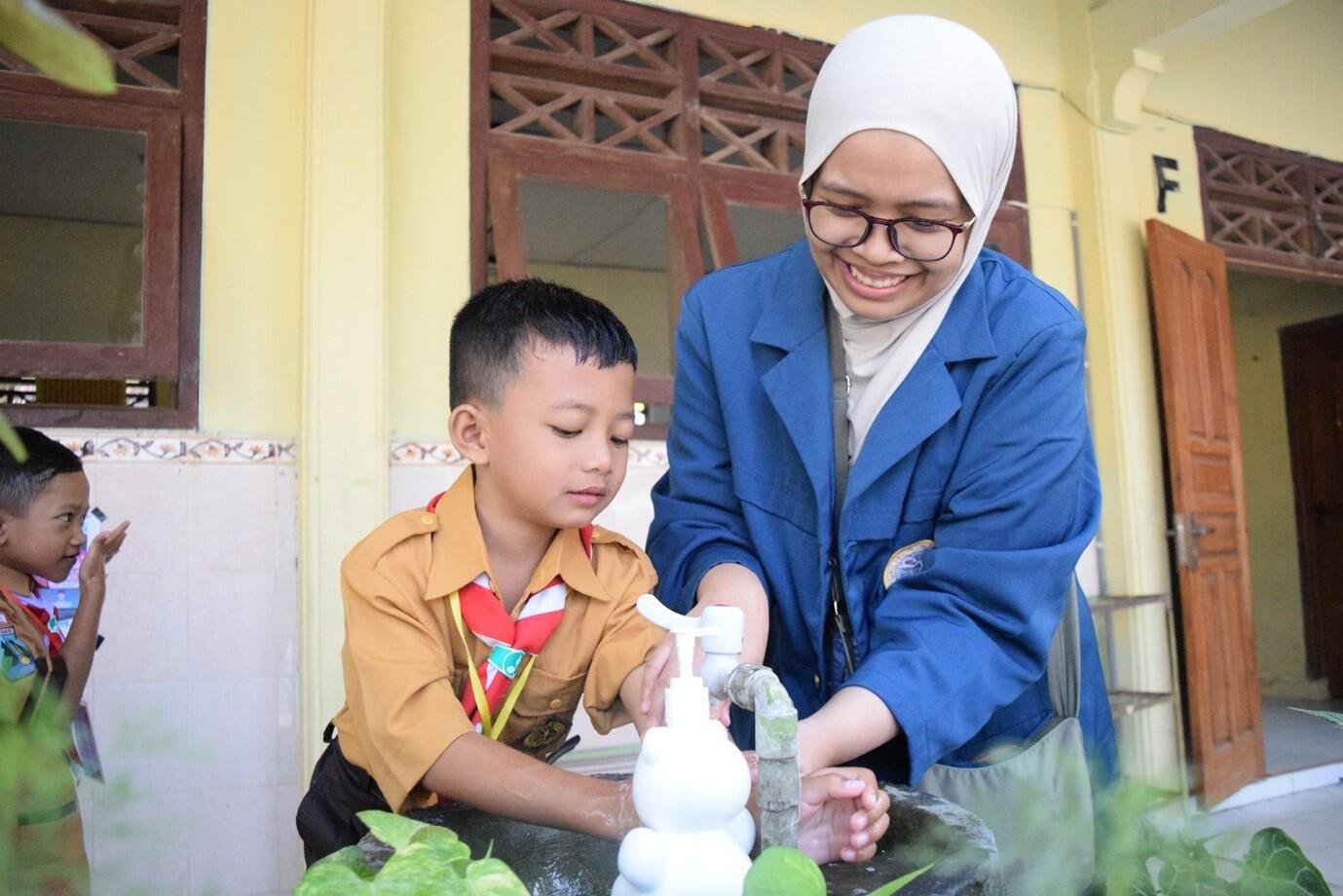 Foto 1. Mahasiswa KKN-BBK 8 UNAIR mendampingi siswa SDN 1 Sukorejo mempraktikkan enam langkah cuci tangan pakai sabun sesuai standar WHO. (Dok. KKN-BBK 8 Sukorejo)