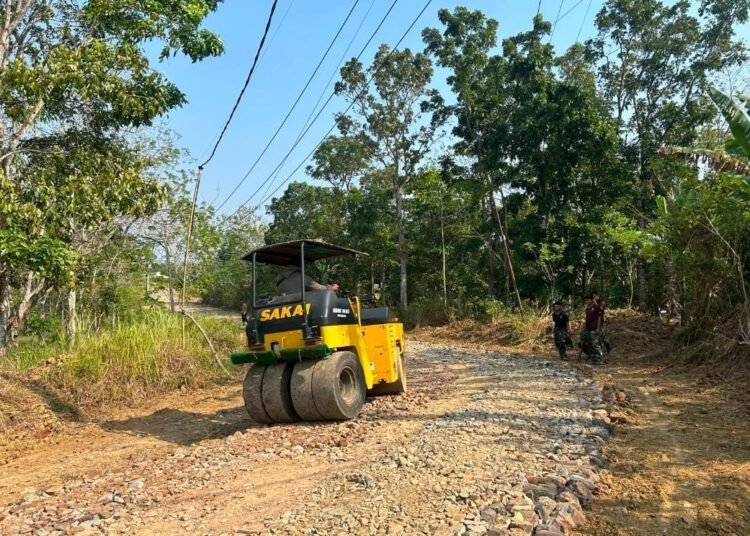 Proses pemadatan jalan menggunakan alat berat dalam kegiatan TMMD Ke-129 Kodim 0601/Pandeglang di Desa Pasirgadung, Kecamatan Patia.
