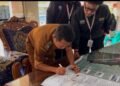 Foto Proses penandatanganan Peta Infografis Desa Harjokuncaran oleh perangkat Desa Harjokuncaran (Sumber: Dokumentasi Pribadi)