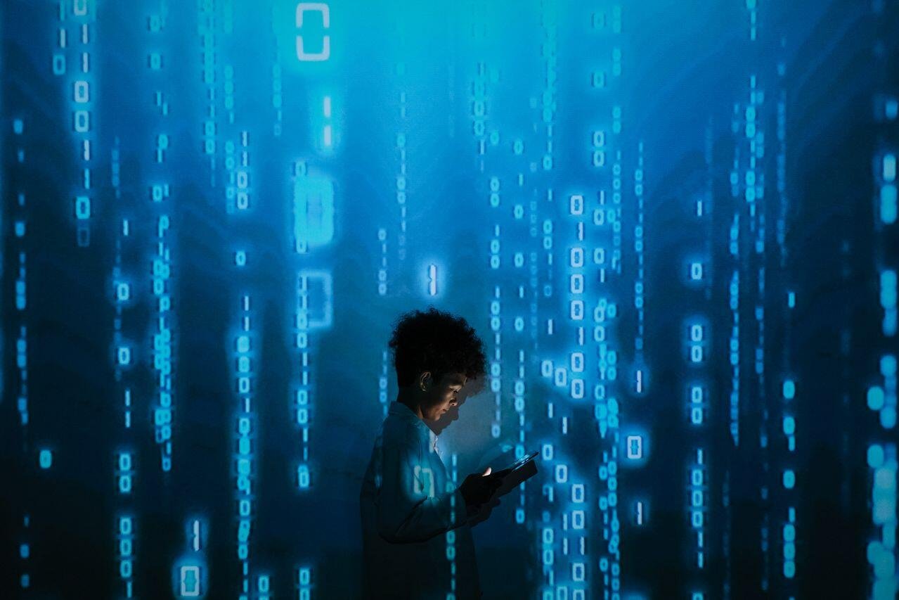 Approximately 30% of U.S. adults learning a new language said they have used AI to help them practice. - Photo by <a href="https://www.pexels.com/photo/person-with-smartphone-standing-in-projection-of-zeros-and-ones-9783812/" target="_blank" rel="noopener">Ron Lach